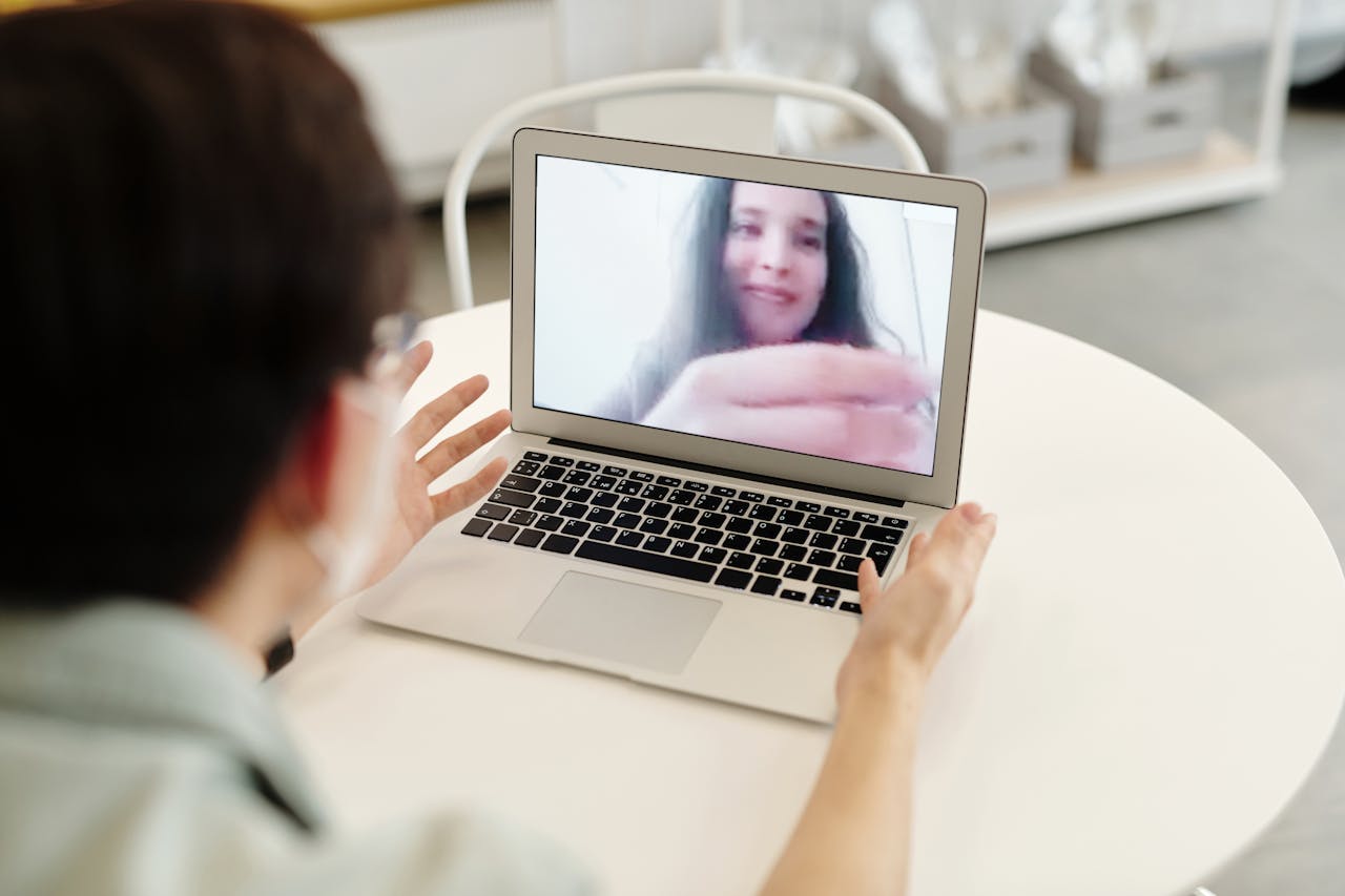 why-choose-us A person having a video call on a laptop, indoors, showcasing digital communication.